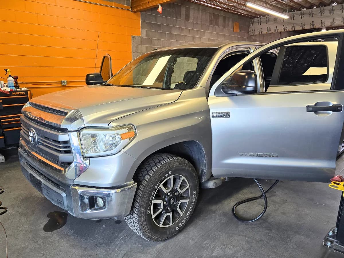 Vehicle being inspected inside the Benchmark Automotive Service repair bay